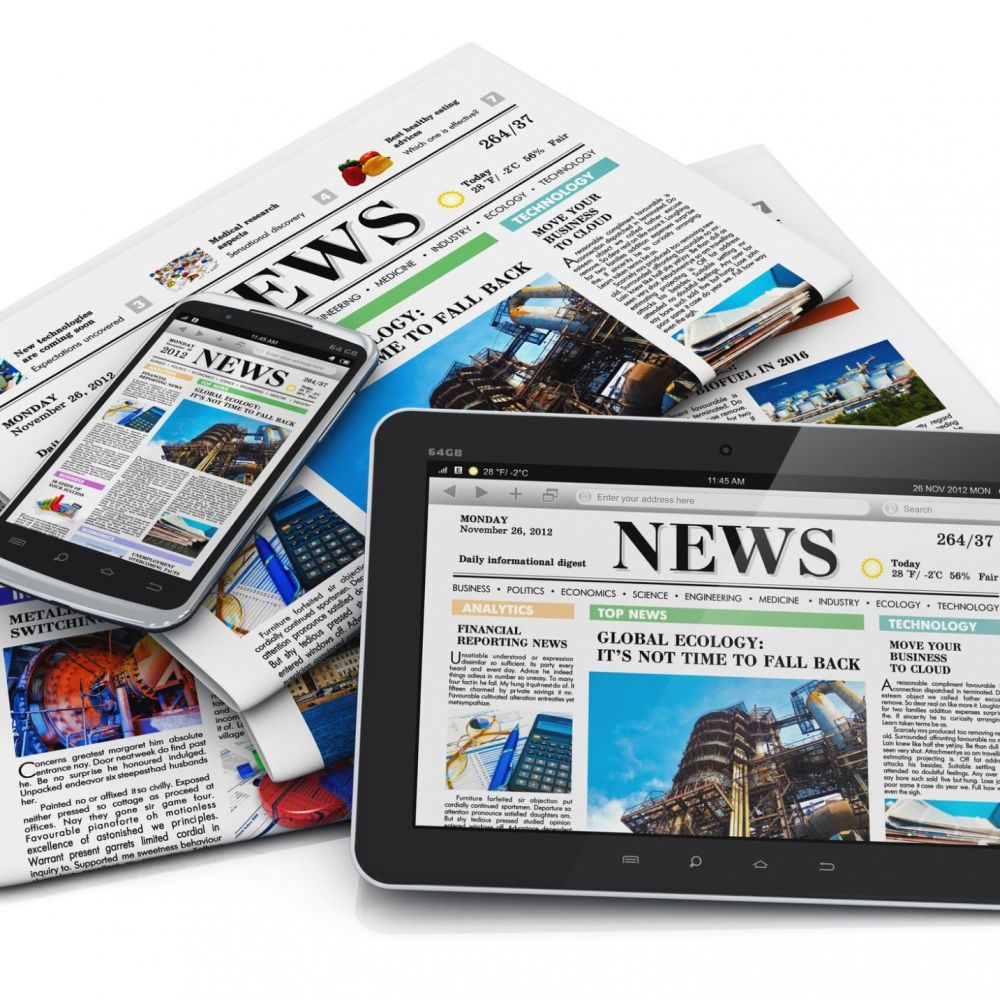 pile of newspapers with laptop laying on top